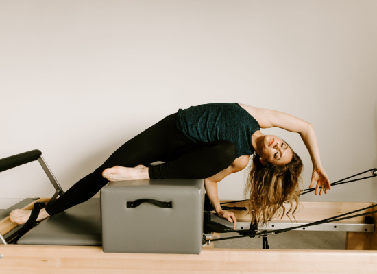 Pilates instructor Erica Breen demonstrating an exercise on a reformer